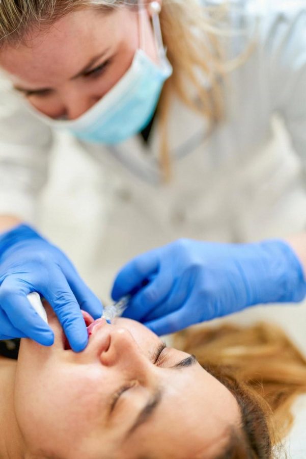 Dermatologist in gloves and mask performing a filler injection on a patient at a UAE clinic